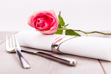 Image showing Table setting with a single pink rose