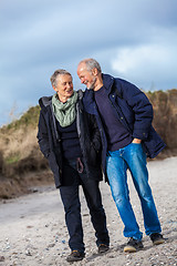 Image showing happy elderly senior couple walking on beach