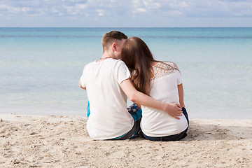 Image showing romantic young couple sitting on the beach in summer