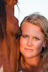 Image showing young woman training horse outside in summer