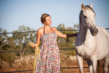 Image showing young woman walking a road with horse