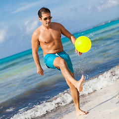 Image showing happy young adult man playing beach ball in summer 