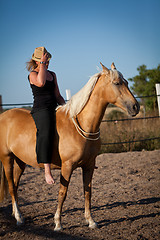 Image showing young woman training horse outside in summer