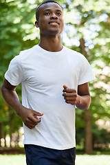 Image showing young african athletic runner jogger in park