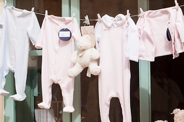 Image showing baby clothing and teddy bear in window