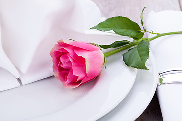 Image showing Table setting with a single pink rose