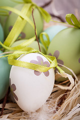 Image showing Colourful green Easter eggs in straw