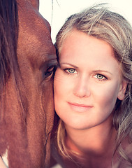 Image showing young woman training horse outside in summer