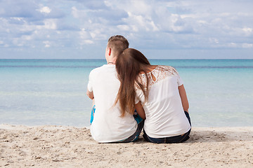 Image showing romantic young couple sitting on the beach in summer