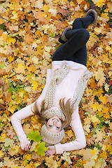 Image showing attractive young woman relaxing in atumn park outdoor