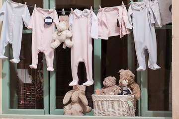 Image showing baby clothing and teddy bear in window