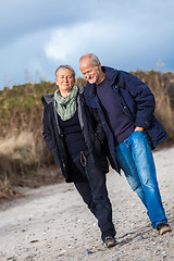 Image showing happy elderly senior couple walking on beach