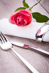 Image showing Table setting with a single pink rose