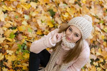 Image showing attractive young woman relaxing in atumn park outdoor