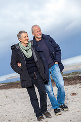 Image showing happy elderly senior couple walking on beach