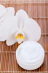 Image showing cosmetic face cream on wooden background 