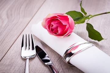 Image showing Table setting with a single pink rose