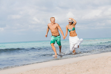 Image showing young happy couple walking on beach sunset holiday