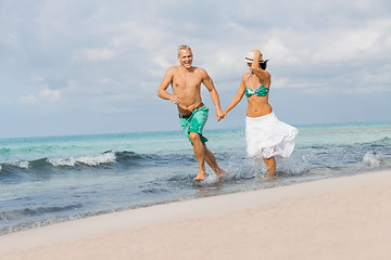 Image showing young happy couple walking on beach sunset holiday