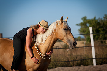 Image showing young woman training horse outside in summer