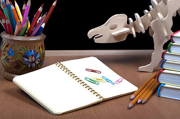 Image showing Model of dinosaur, school board and pile books, notebook