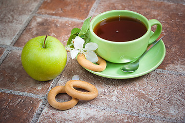 Image showing Cup of tea with an apple