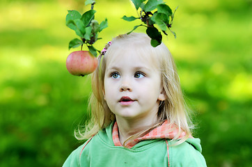 Image showing little girl thoughtfully looks at the apple 