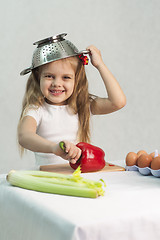 Image showing Girl playing in cook put a colander on his head