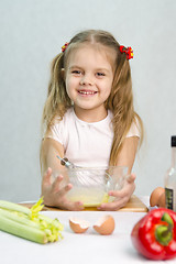 Image showing Girl playing a cook churn whisk eggs in glass bowl