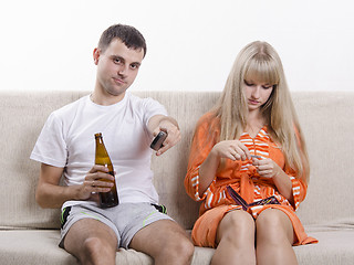 Image showing He is watching TV with a beer, it handles nails nail file