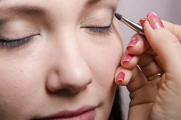 Image showing Makeup artist colors upper eyelids model