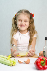 Image showing Girl playing a cook churn whisk eggs in glass bowl