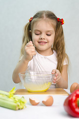 Image showing Girl playing in a cook churn whisk eggs glass bowl