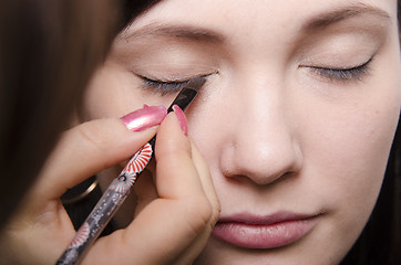 Image showing Makeup artist colors eyelashes model