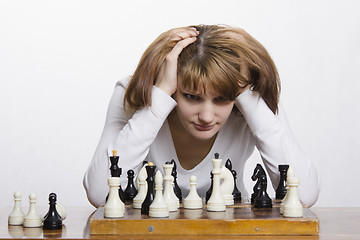 Image showing Young girl to be considering a move during the game of chess