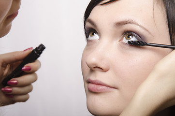 Image showing Makeup artist colors eyelashes model