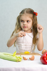 Image showing Girl playing in a cook churn whisk eggs glass bowl