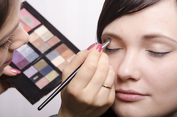 Image showing Makeup artist colors upper eyelids model