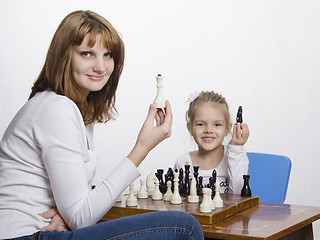 Image showing Mother explains daughter purpose of the chess pieces