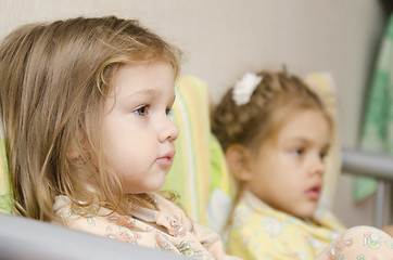 Image showing Two children sit on couch and look to right