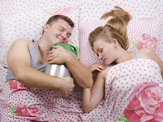 Image showing couple in bed-husband sleeps with a barrel of beer