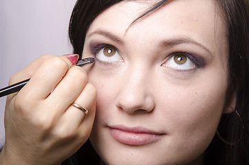 Image showing Makeup artist colors eyelashes model