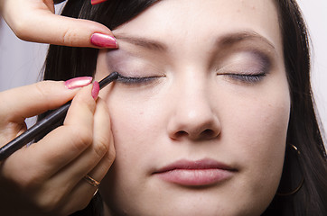 Image showing Makeup artist colors upper eyelids model