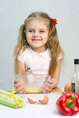 Image showing Girl playing a cook churn whisk eggs in glass bowl