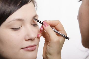 Image showing Makeup artist brings eyebrow pencil model