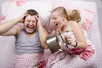 Image showing She woke and frightened boy in bed, slamming lid on pan