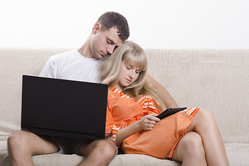 Image showing Guy and girl asleep, sitting on couch with laptop