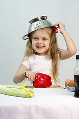 Image showing Girl playing in cook put a colander on his head