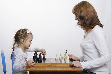 Image showing Mother teaches daughter to play chess