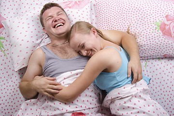 Image showing Young couple lying in bed and laughs